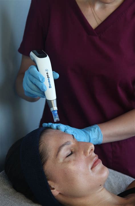 Aesthetician performing a HydraFacial treatment on a client's face