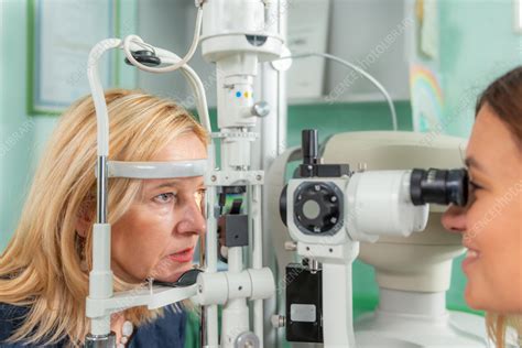 A slit-lamp examination in progress, showing the ophthalmologist examining a patient's eye.