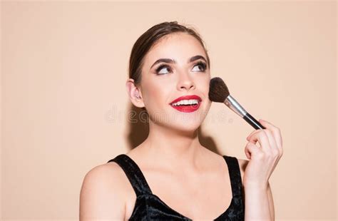 Close-up of a makeup artist's hand holding a high-quality foundation brush.