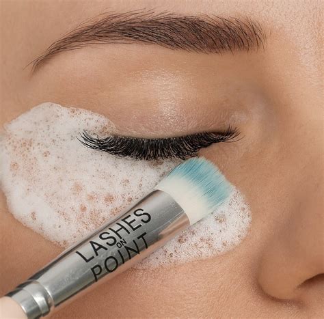 Visual representation of a foaming cleanser being applied to lashes with a soft brush.