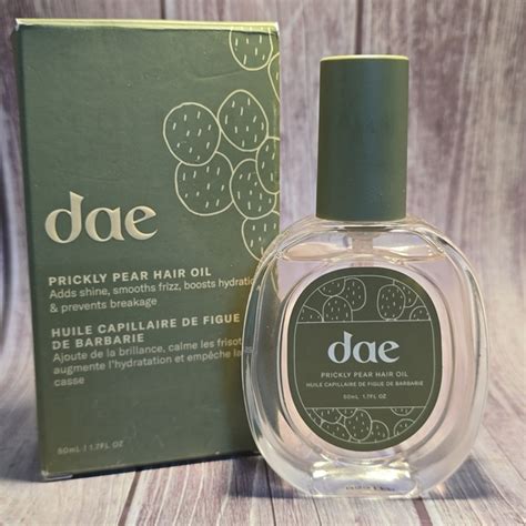 Close-up of a bottle of Dae Prickly Pear Hair Oil with a dropper, surrounded by prickly pear fruit and cactus elements.