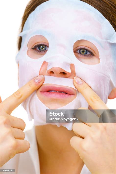 Woman applying a sheet mask to her face