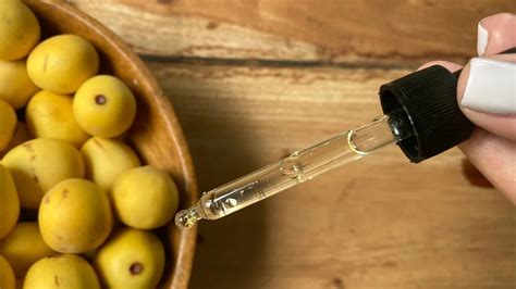 Close-up image of a drop of marula oil on a fingertip, symbolizing application to the face