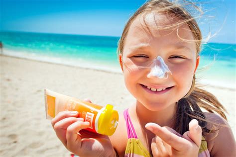 Sunscreen bottle and a person applying sunscreen to their face