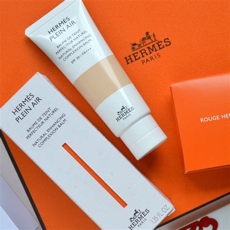 An elegant Hermès beauty product packaging, possibly the complexion balm or a related item, showcasing the brand's signature luxury aesthetic.