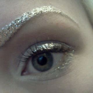 Close-up of eyebrows with silver glitter applied.