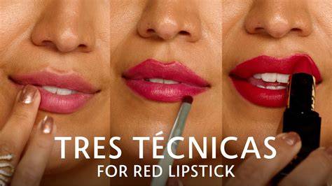 A lip brush precisely applying red lipstick to the cupid's bow.