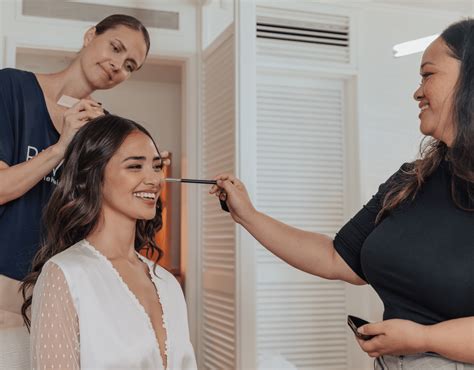 A bride and her bridesmaids getting their hair and makeup done in a relaxed, luxurious setting.