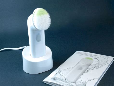 An image of the Clinique Sonic System Purifying Cleansing Brush with its charging dock and packaging.