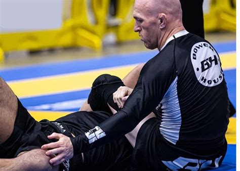 Grappler wearing a blue Jiu-Jitsu rash guard during a roll