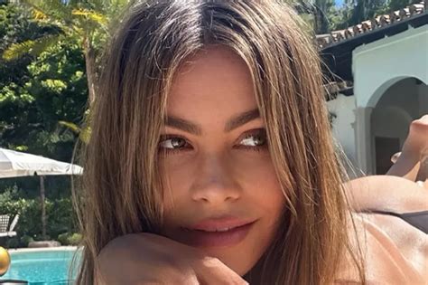 Sofia Vergara posing topless in a G-string thong by the pool.
