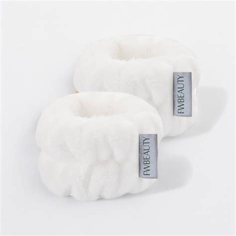 A pair of fluffy, absorbent wristbands designed for skincare routines.