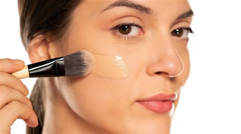 A makeup artist applying foundation with a damp beauty sponge for a flawless finish.