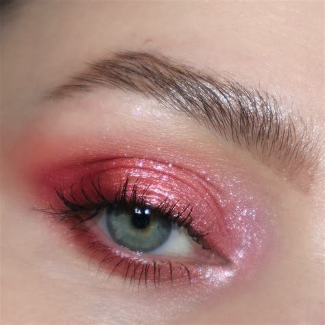 Close-up of an eye with a soft pink eyeshadow applied and blended, with an optional brown eyeliner.