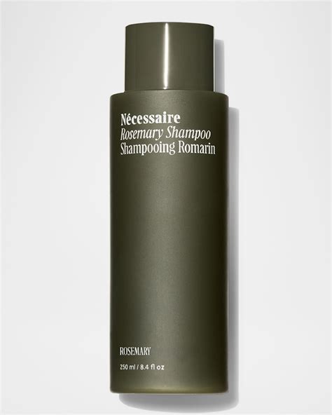 A bottle of Nécessaire Rosemary Shampoo with rosemary sprigs for visual appeal.