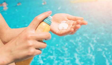 A person applying sunscreen to their face, emphasizing post-treatment sun protection.