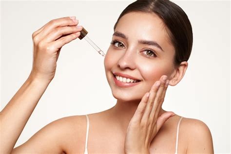 A woman applying vitamin C serum to her face in the morning.