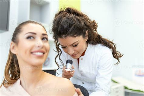A dermatologist examining a patient's skin during a cancer screening.
