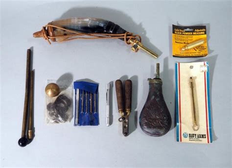 Collection of essential cap-and-ball shooting tools: powder flask, measure, nipple wrench, and screwdrivers