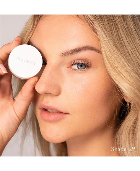A close-up of RMS Beauty's UnCoverup Concealer being applied with a finger.