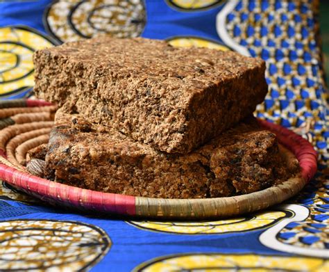 Traditional African black soap with visible plant fibers and ash