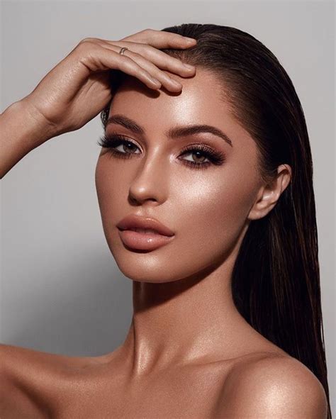 A model with a warm, bronzed makeup look featuring soft shimmer and sculpted features.