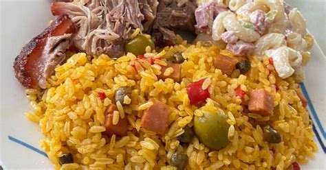 A festive platter of Puerto Rican Pernil served with Arroz con Gandules and Tostones.