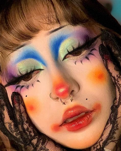 A model with dramatic clown eye makeup, including colorful eyeshadow, thick eyeliner, and false lashes.