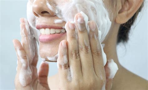 Close-up photo of a person gently massaging an oil cleanser onto their dry face.