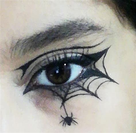 A model with intricate spiderweb eyeliner extending from her eyes, embodying a spooky aesthetic.
