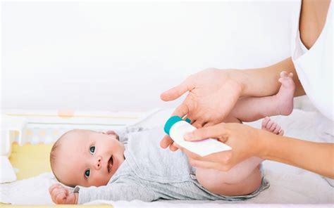 Illustration of a person applying cream to a baby's diaper area.