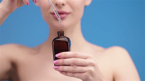 Close-up of a woman applying facial serum with a dropper